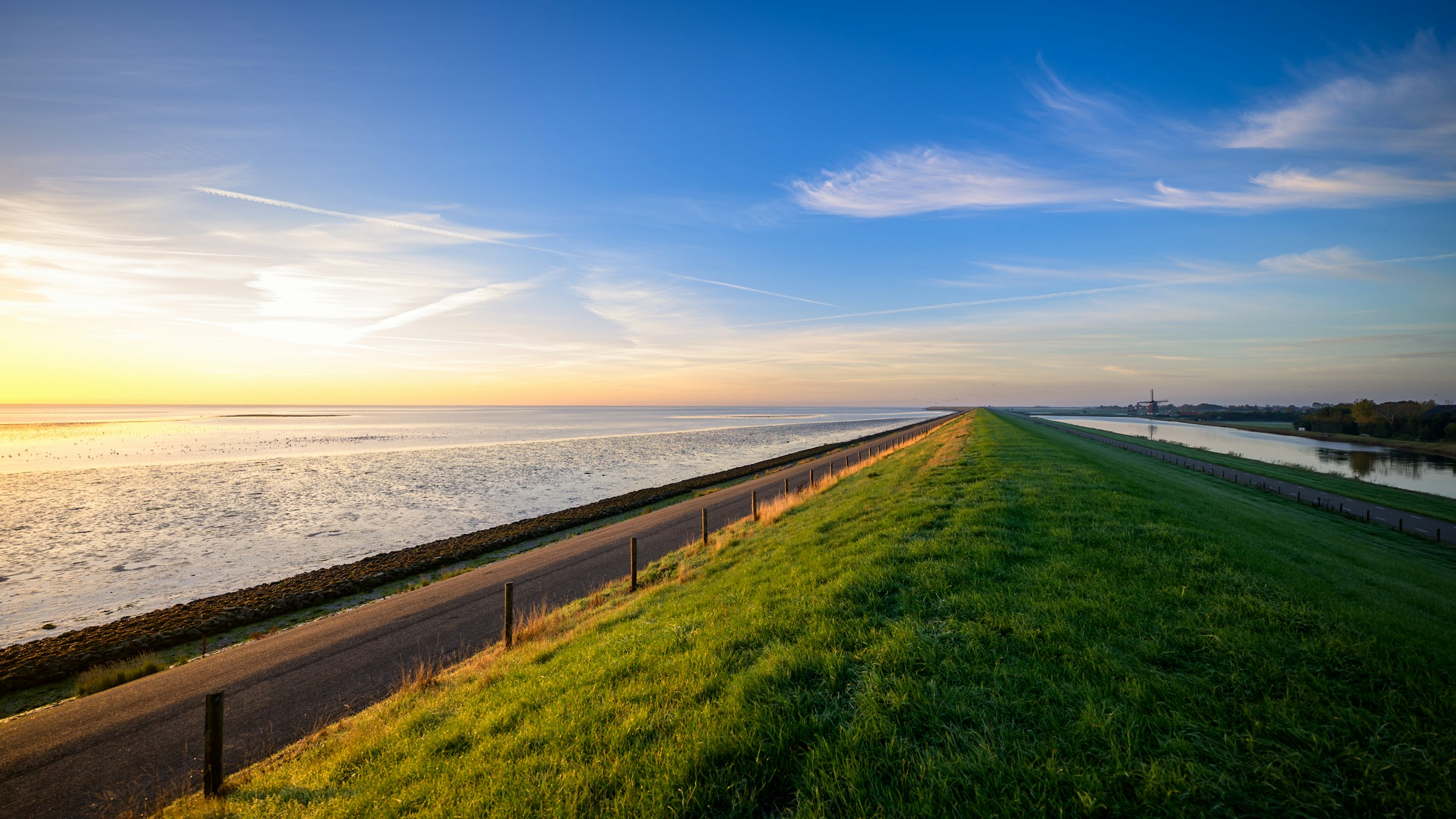 Dijk langs de Waddenzee bij laagstaande zon